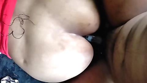 A brunette in a black dress is getting fucked in a car